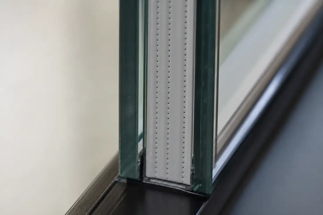 Detailaufnahme des Randverbunds einer Isolierglasscheibe mit Abstandhalter aus Kunststoff